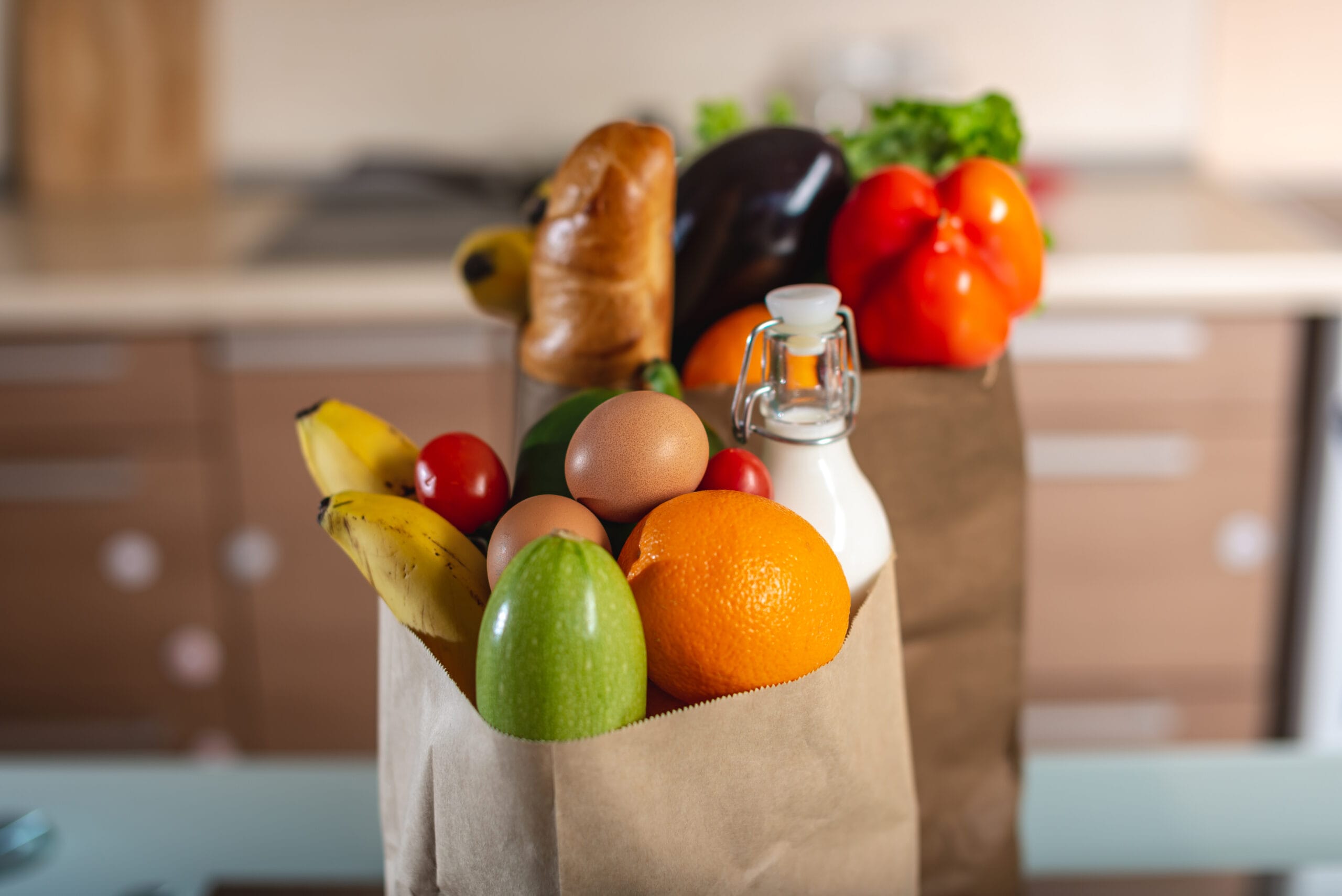 Full paper bags with foods on the table on the background of the kitchen. Healthy eco products for a balanced diet. budget methods