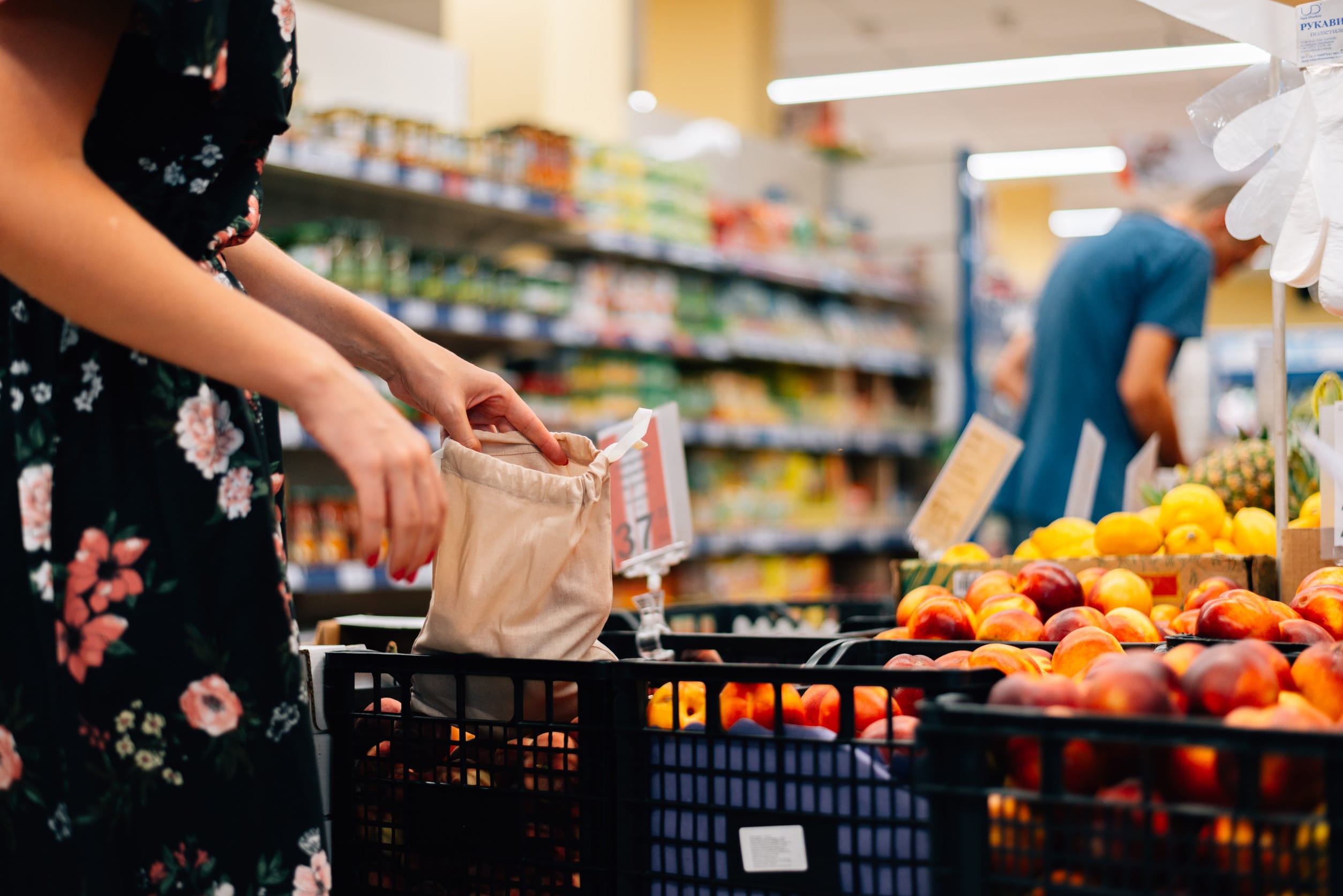 Woman is chooses fruits and vegetables food market. Reusable bag shopping. Zero waste