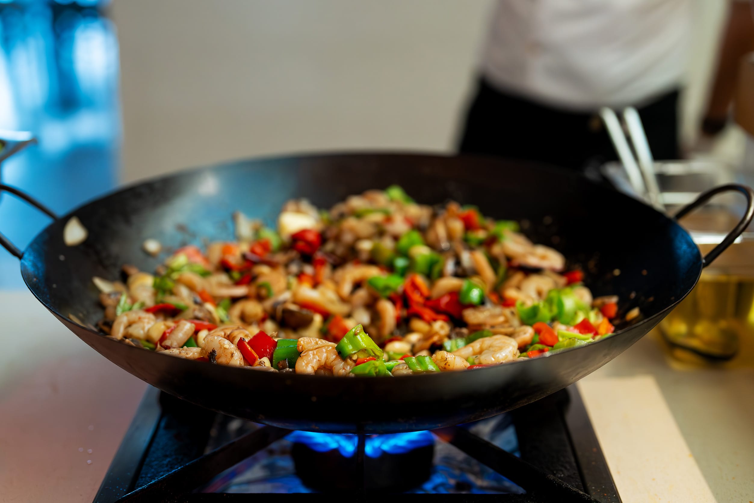 The chef cooks shrimps with vegetables in a wok. skillet dinners