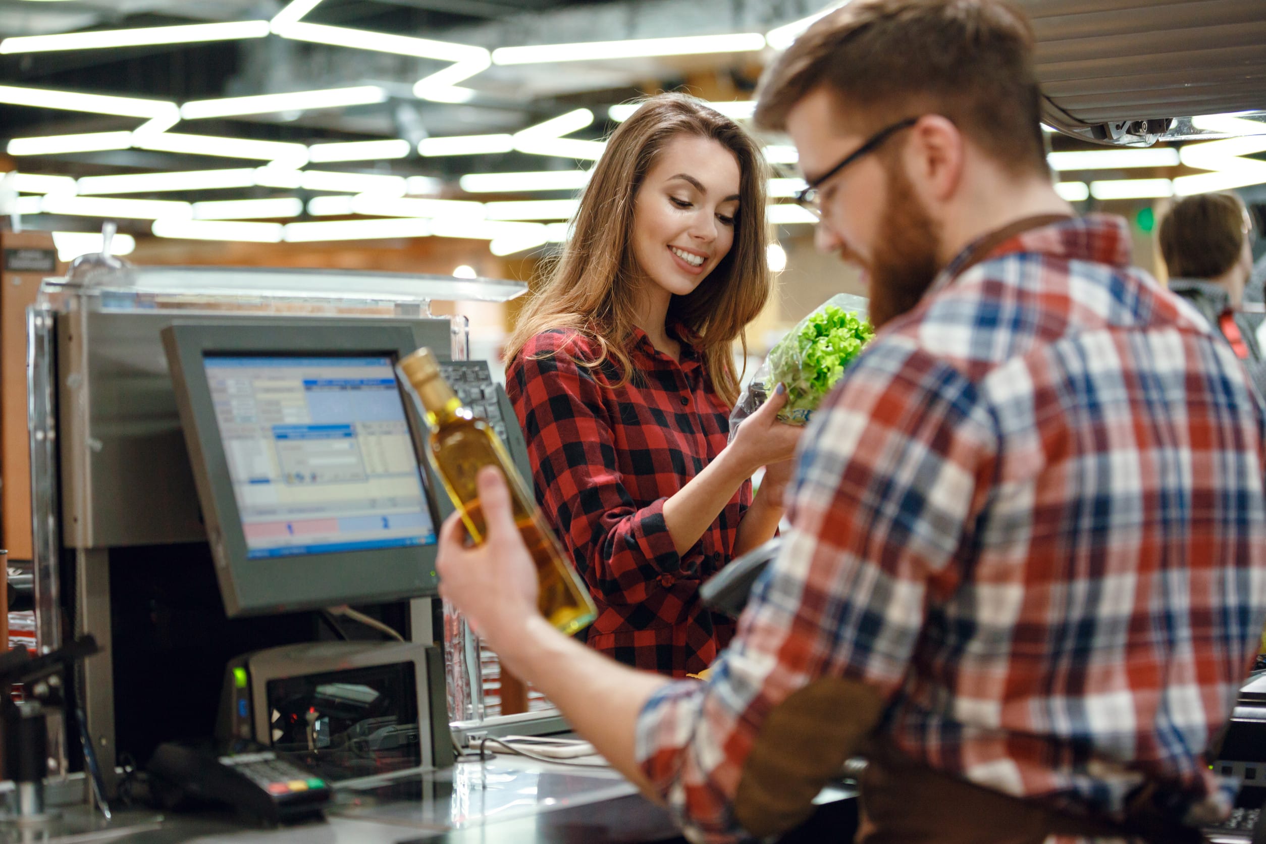 Smiling young lady standing in supermarket shop cashier decline