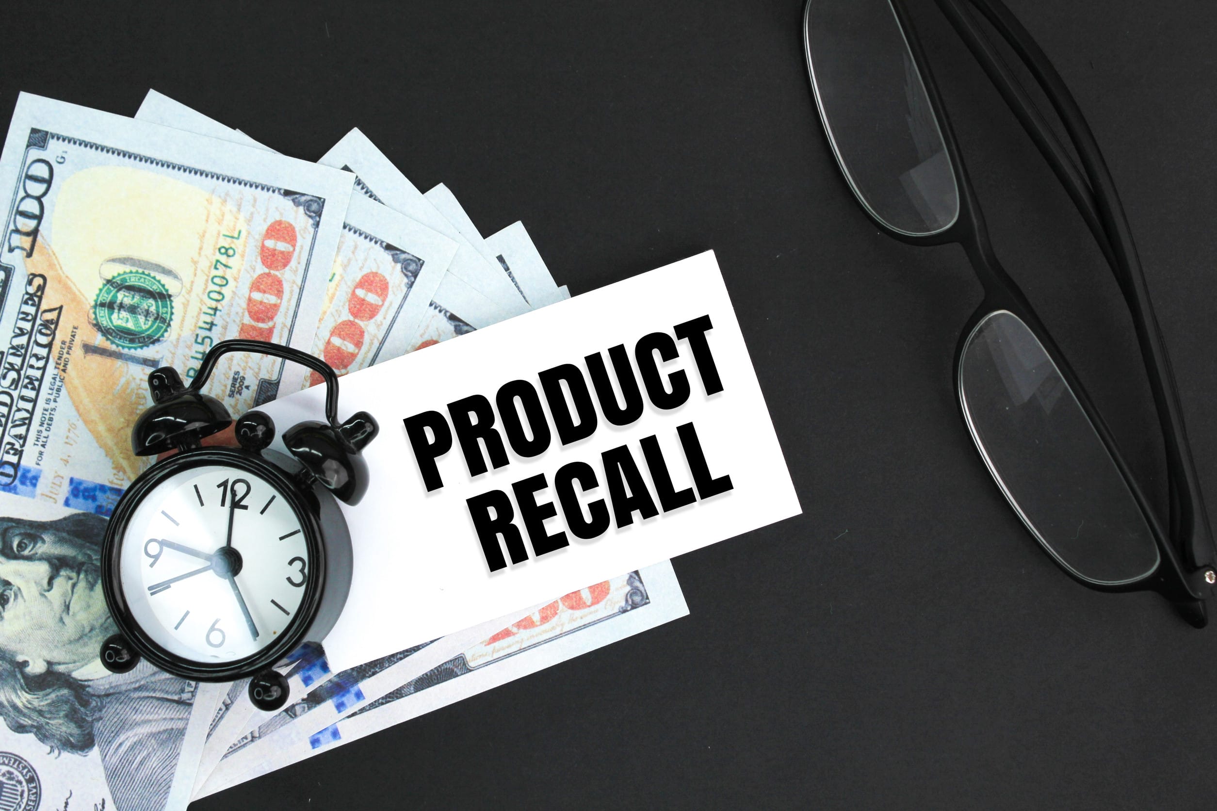 glasses, banknotes and alarm clocks with the words Product Recall product recall